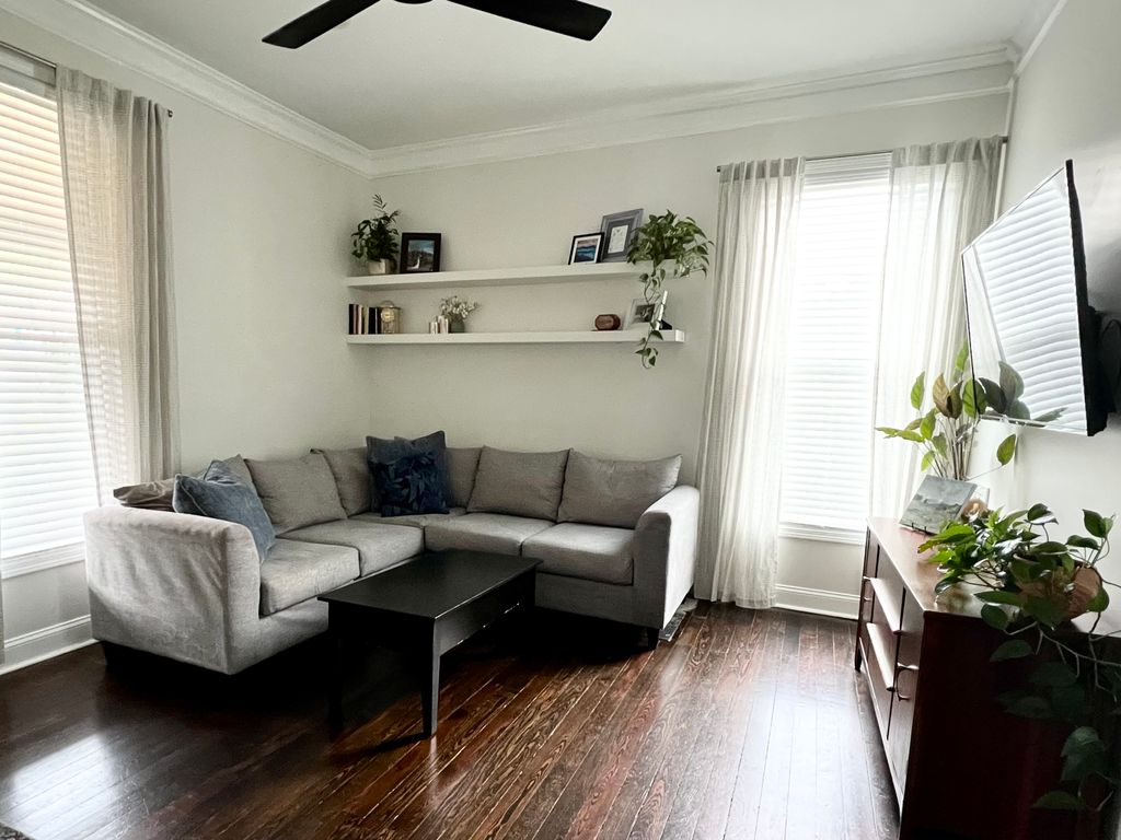 Wall shelf installation in progress above a covered sofa